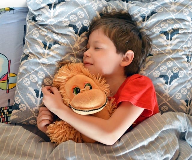 a boy sleeping in his bed