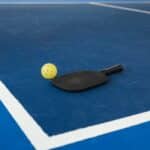 a pickleball court, racket and ball