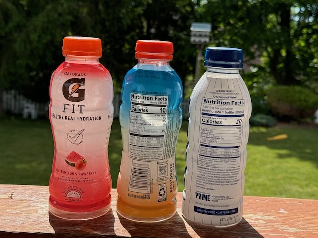 two bottles of Gatorade and one bottle of Prime hydration drink