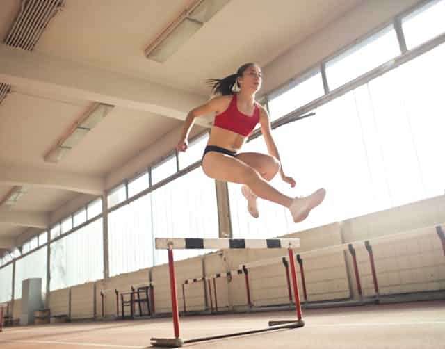 an attractive girl doing hurdles